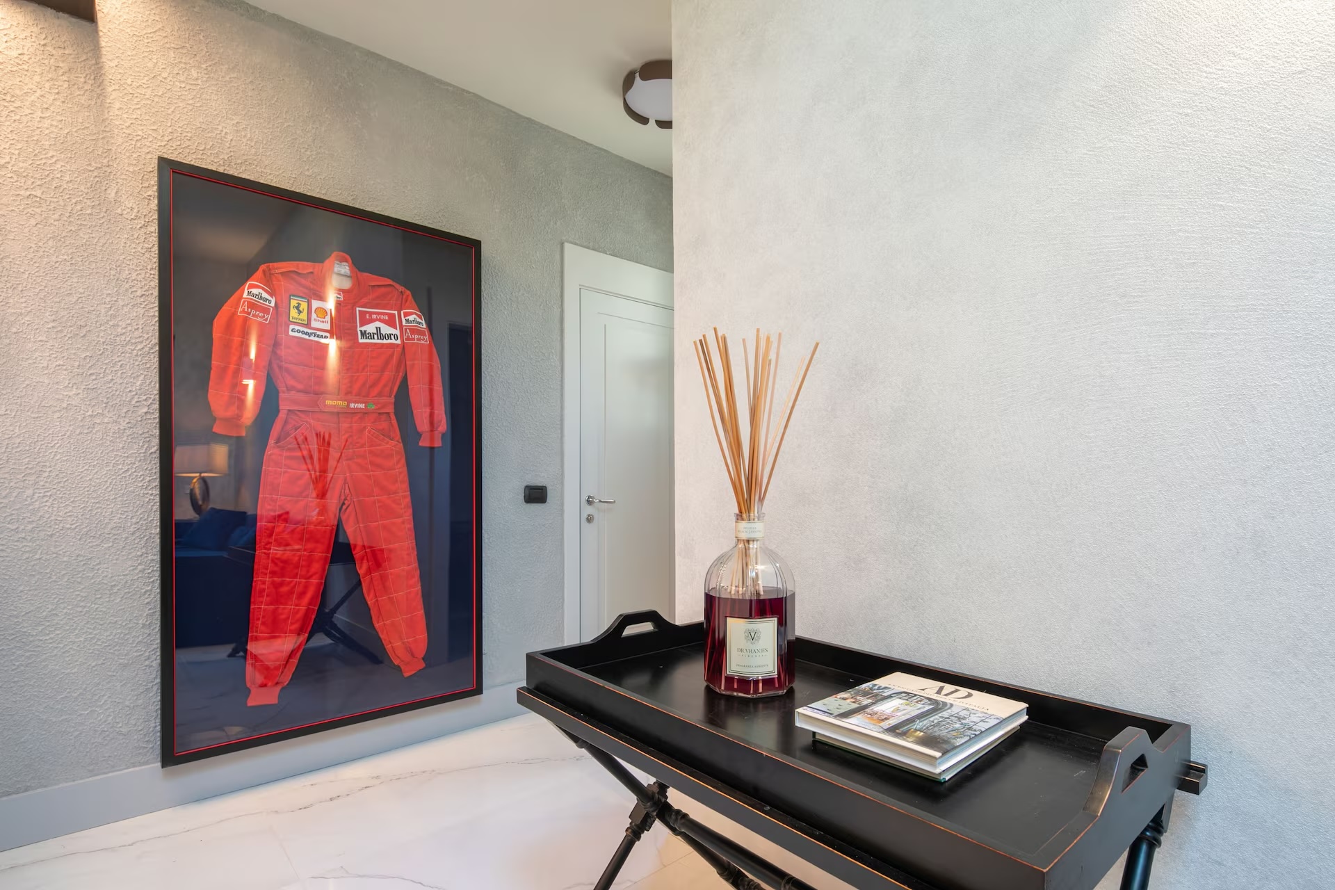 Ferrari suit display with black lacquer console and fragrance tray