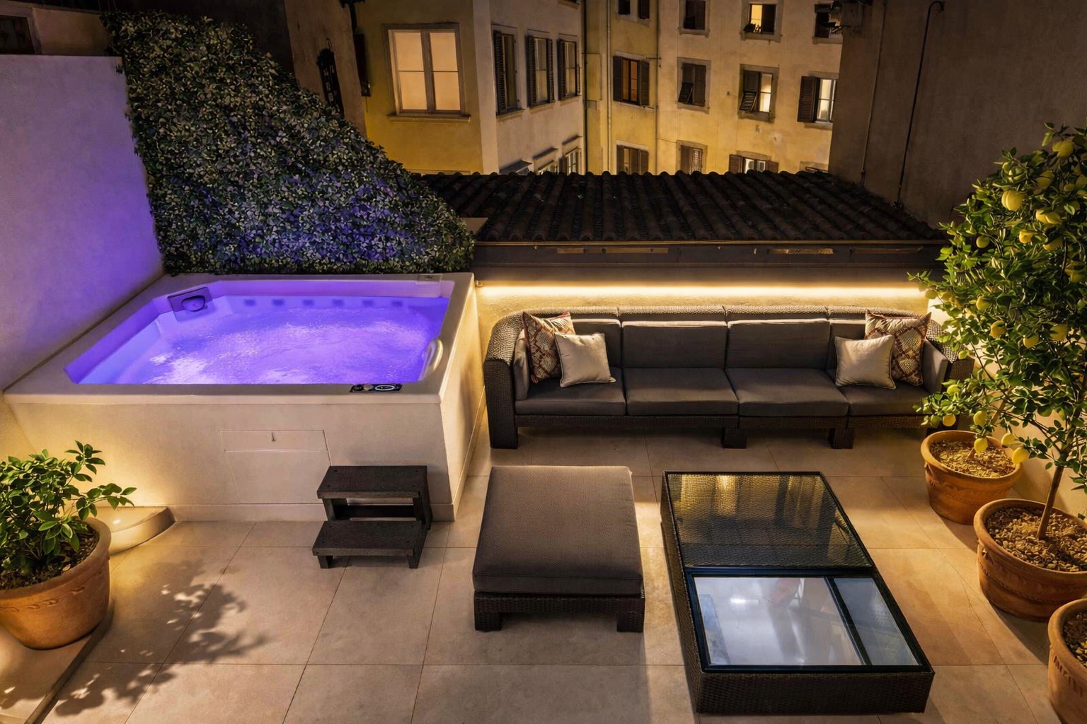 Private terrace with hot tub, lounge seating, and Florence rooftops at night